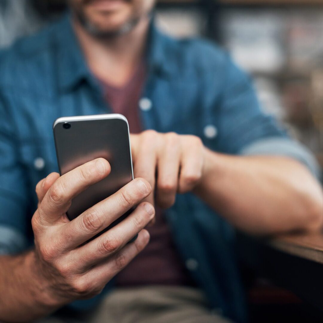 A man is holding his phone in his hand.