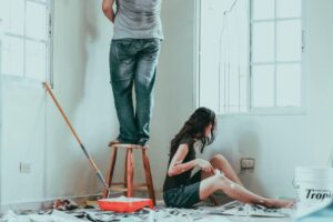 A man and woman painting a wall